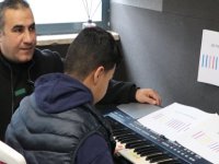 Kendisi gibi engelli çocuklara bağlama ve piyano dersi veriyor